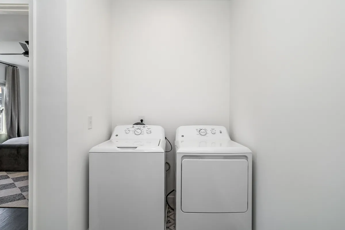 A practical laundry area featuring a washing machine and drying machine, set up for convenient in-home laundry tasks. The setting is clean, functional, and signals ease of everyday routines.